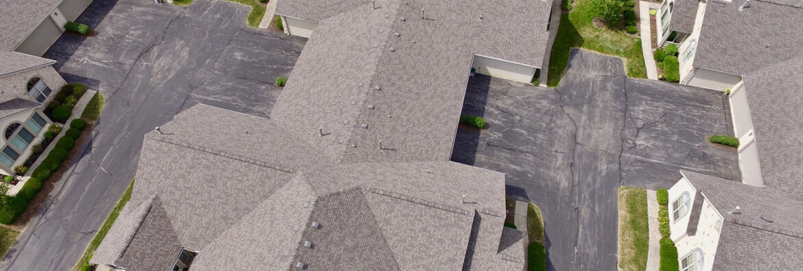 a set of commercial roofs with grey and brown shingles for multi family apartments